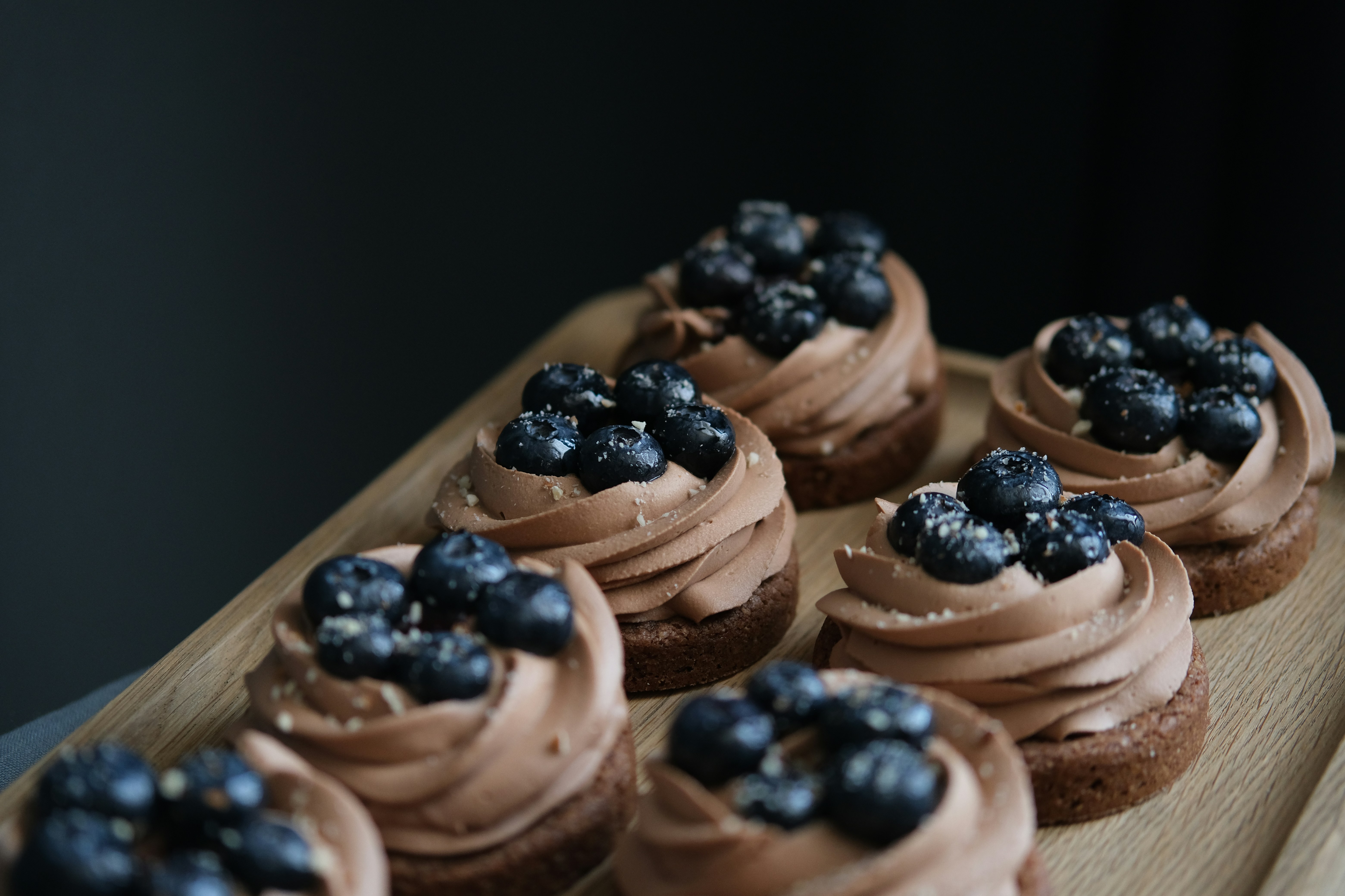 Macarons, cake, chocolate chip cookies, and cupcakes arranged in a commissary bakery setting.